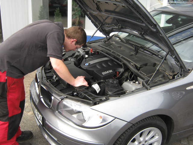 Mechaniker bei der Motorraum-Inspektion